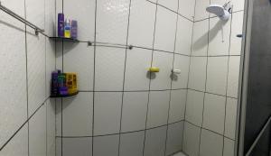 a bathroom with a shower with white tiles at Casa in Garanhuns