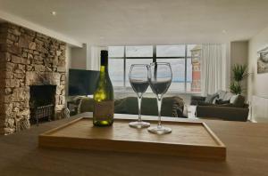 two wine glasses and a bottle on a table at Clock Tower Apartments 1 in Morecambe