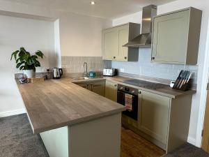 a kitchen with a wooden counter top and a sink at Clock Tower Apartments 1 in Morecambe