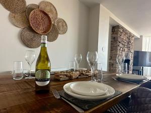 a bottle of wine on a wooden table with plates and glasses at Clock Tower Apartments 1 in Morecambe +8 photos