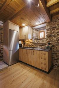 a kitchen with a stainless steel refrigerator and wooden cabinets at casa Robaleira in Cedeira