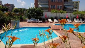 a swimming pool with flowers in front of a building at Студио - Морско бягство in Primorsko
