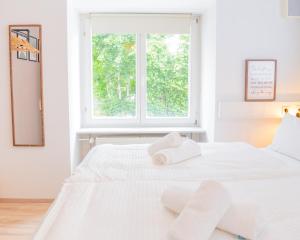 a white bedroom with a white bed with towels on it at Modern & Groß, Heimkino mit Popcorn, Parken, nah am See, ideal für Familien in Lenzkirch +20 photos