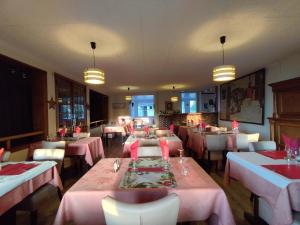 a dining room with pink tables and white chairs at Aux Trois Rois in Pont-sur-Yonne