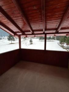 an empty room with a view of a snow covered field at Cabana Matei in Coasta Leşului