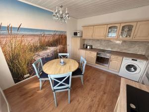 a dining room with a table and chairs and a kitchen at Ferienwohnung Gitti Ueckermünde in Ueckermünde