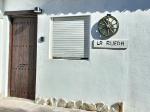 a building with a door and a clock on it at La Rueda, campo y playa en el Medano in El Médano