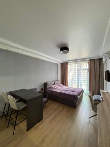 a bedroom with a bed and a table and a dining room at Dreamside Apartment in Chakvi
