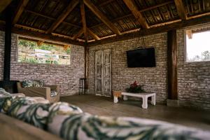 un soggiorno con una TV su un muro di mattoni di Eucaliptus Spa Resort a Dapa