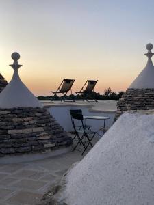 un groupe de chaises assises au-dessus d'un toit dans l'établissement I PapaTrulli MiniResort, à Martina Franca