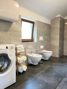 ein Badezimmer mit Waschmaschine und Waschbecken in der Unterkunft Apartma Pergola in Sečovlje