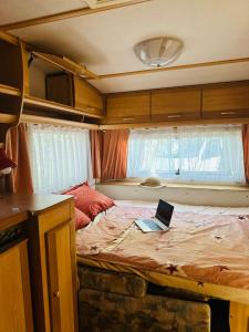 a laptop computer sitting on top of a bed at Каравана Синята Маймуна плаж Градина # RV Blue Monkey on the beach in Chernomorets