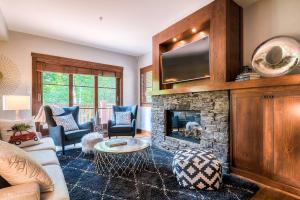 Una sala de estar con un sofá y una chimenea. en Étoile du Matin Tremblant Luxury Ski In Ski Out, en Mont-Tremblant
