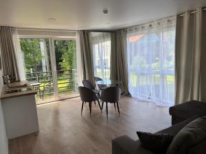 a living room with a table and chairs and a balcony at Seaside apartments 4 in Palanga