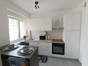 a kitchen with white cabinets and a table with hats on it at Studio apartman Terezija in Županja