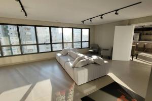 a living room with a white couch and some windows at Studio Novo Alto Padrão - Centro in Curitiba +79 photos