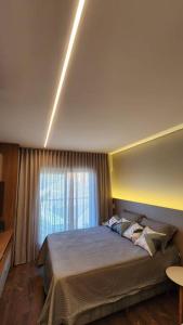 a bedroom with a large bed and a window at Studio Novo Alto Padrão - Centro in Curitiba