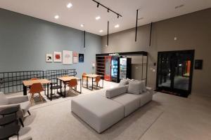 a living room with a white couch and a table at Studio Novo Alto Padrão - Centro in Curitiba