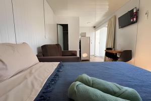 a bedroom with a bed and a living room at LN Studios in Uberlândia
