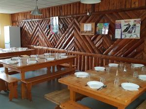 a dining room with wooden walls and wooden tables at La Marmotte De La Meije in Le Bourg-dʼOisans