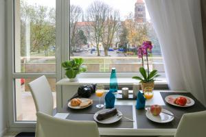 Apartament Świętojańska في غدانسك: طاولة مع طعام ومشروبات ونافذة