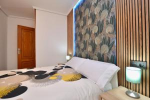 ヒホンにあるSapore di Sale - GARAJE incluido - Centro Gijón - Vivienda de temporada corta duraciónの花柄の壁紙が貼られたベッドのある寝室
