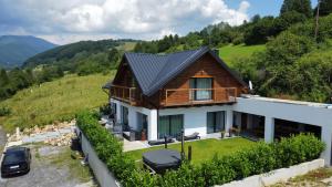 una casa con techo de metal en una colina en Chalet Black Deer, en Mýto pod Ďumbierom