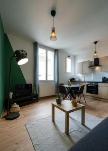 a living room with a table and a kitchen at Appartement Centre-Ville 2/4 personnes in Épernay