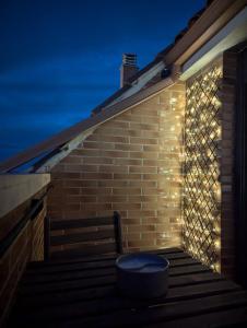 a brick wall with a bench with lights on it at Puerta del Noroeste in Benavente