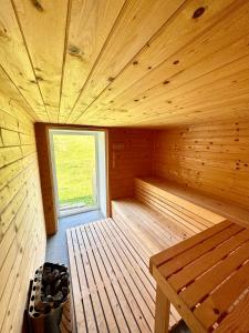a wooden sauna with a bench and a window at Apilandia Nanos in Vipava +1 photo
