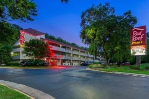 a building with a pool roof and a parking lot at Red Roof Inn PLUS+ Washington DC - Alexandria in Alexandria