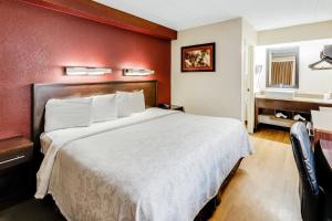 a hotel room with a bed and a desk at Red Roof Inn PLUS+ Washington DC - Alexandria in Alexandria