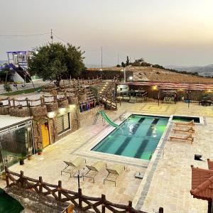 einen Pool mit Stühlen und einer Rutsche in der Unterkunft tal alazaraq in Salt