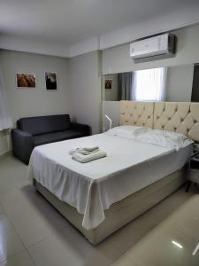 a bedroom with a large bed and a couch at Flat 6 Pessoas 2 Quartos Ponta Negra - 1404 in Natal