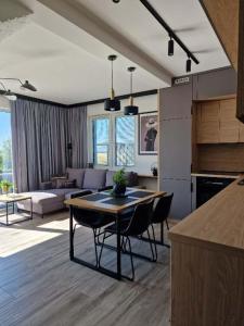 eine Küche und ein Wohnzimmer mit Tisch und Stühlen in der Unterkunft Dom Choczewo Zielony Zakątek in Choczewo