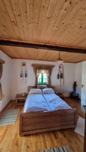 Un dormitorio con una cama grande con techo de madera. en Pajisti Verzi / Green Meadows Guest House, en Vişeu de Sus