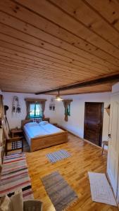 1 dormitorio grande con 1 cama y techo de madera en Pajisti Verzi / Green Meadows Guest House, en Vişeu de Sus