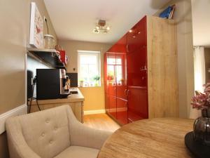 ドルヌマージールにあるFerienwohnung in Dornumersiel für 6 Personenのキッチン(赤いキャビネット、テーブル、椅子付)