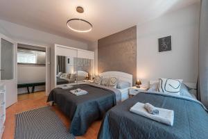 a bedroom with two beds and a mirror at City Apartment near Aupark in Košice
