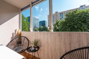 a balcony with two chairs and a large window at City Apartment near Aupark in Košice