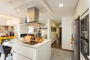 a kitchen with white cabinets and a stove at Downtown Alegria B&B in Tavira