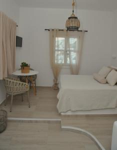 a bedroom with a bed and a table and a chair at Belvedere Studios in Astypalaia Town