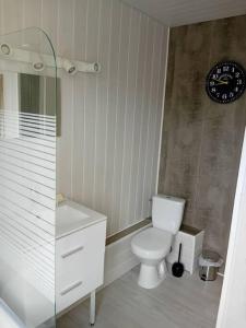 a bathroom with a toilet and a clock on the wall at Maison à Eu proche centre ville et baie de Somme in Eu