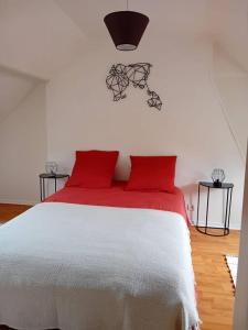 a bedroom with a white bed with red pillows at Maison à Eu proche centre ville et baie de Somme in Eu