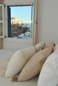 a row of pillows on a bed with a window at Belvedere Studios in Astypalaia Town