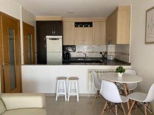a kitchen with a table and chairs and a counter top at Apartamento Combarro chico in Combarro