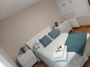a bedroom with a large bed with blue pillows at A Casiña de Amable in Pontevedra