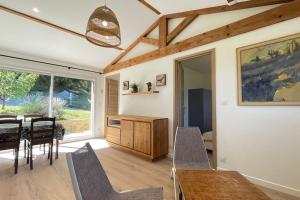a dining room with a table and chairs and a window at maisonnette entre bois et champs in Crest