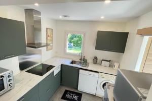 a kitchen with a sink and a dishwasher at maisonnette entre bois et champs in Crest