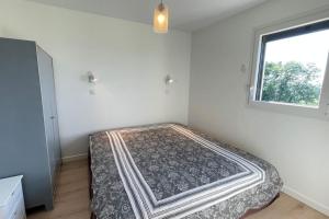 a bed in a room with a window at maisonnette entre bois et champs in Crest